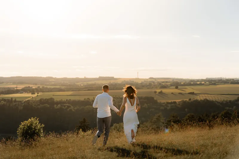 Couple qui s'éloigne main dans la main au coucher du soleil