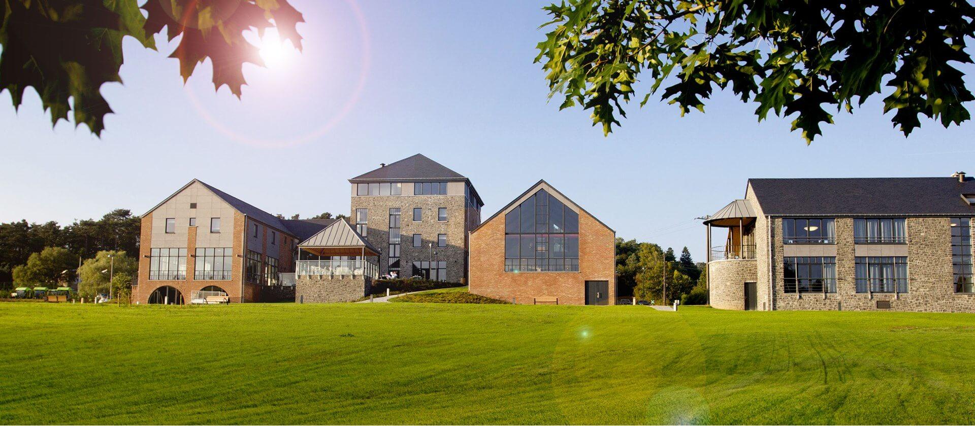 The Azur en Ardenne buildings beside a large lawn in Barvaux-sur-Ourthe